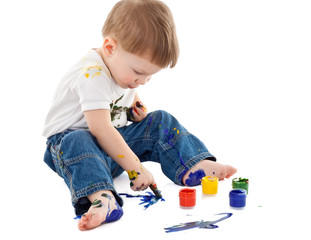little boy painting on the floor