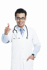Fototapeta premium Portrait of a male doctor showing thumbs up and smiling