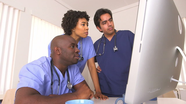 Team of doctors reviewing work on computer