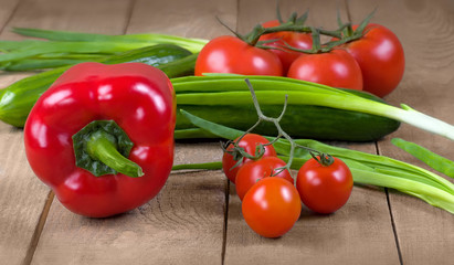 Fresh tomatoes, cucumbers and onions on a wooden board