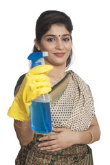 Portrait of a woman holding cleaning fluid