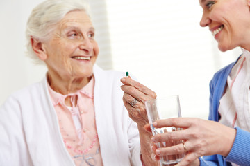 Seniorin nimmt Tablette im Krankenhaus