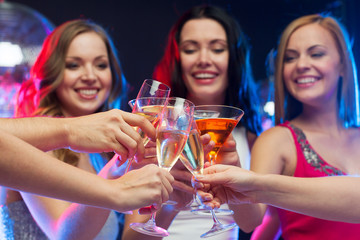 three smiling women with cocktails and disco ball
