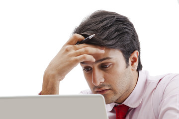 Businessman looking sad while working on a laptop