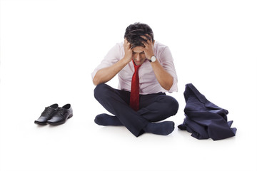 Businessman sitting on the floor with his head in hands