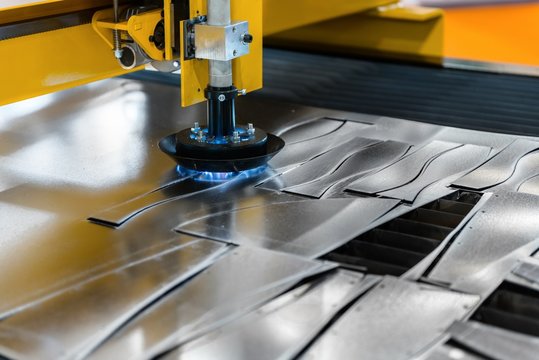 Machine cutting steel in a factory