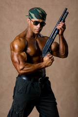 Portrait of a muscular man with a gun