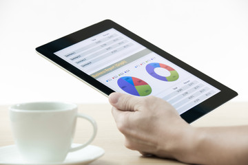 Businessman holding digital tablet and business report