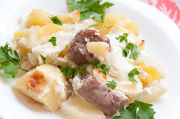 Baked potatoes with meat in a creamy sauce