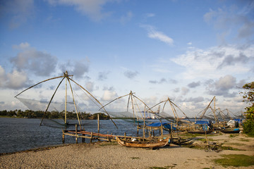 Fototapeta na wymiar Chinese fishing nets and boats on the beach, Cochin, Kerala, India
