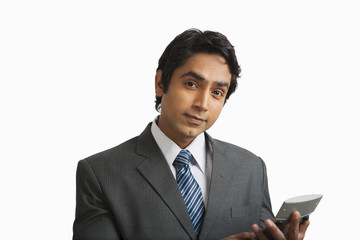 Portrait of a businessman using a calculator