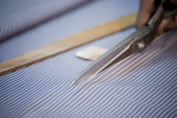 Close-up of a fabric being cut by scissors