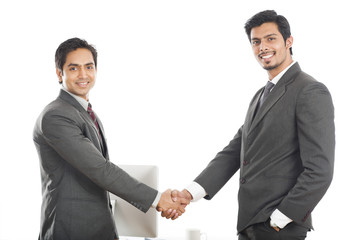 Two smiling businessmen shaking hands