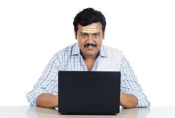 Portrait of a South Indian man using a laptop