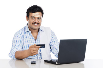 Obraz na płótnie Canvas South Indian man doing online shopping with a credit card