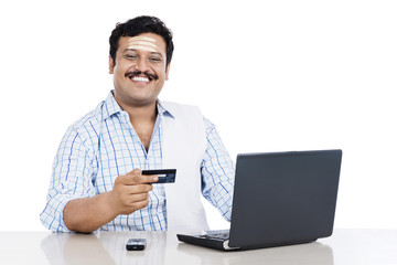 South Indian man doing online shopping with a credit card