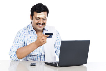 South Indian man doing online shopping with a credit card