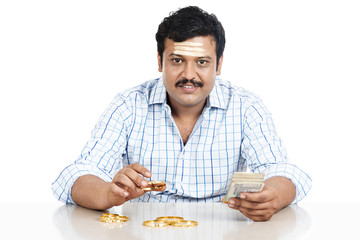 Portrait of a South Indian man holding money and gold bangle