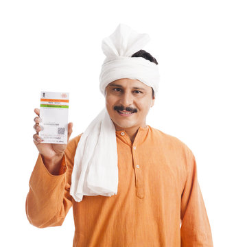 Portrait of a man showing an Aadhaar Card and smiling