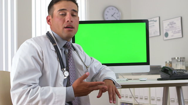 Hispanic doctor talking with green screen on computer in backgro