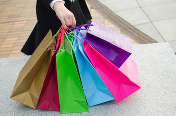 Arm of young woman with shopping bags