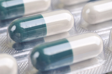 assortment of green pills and capsules in blister