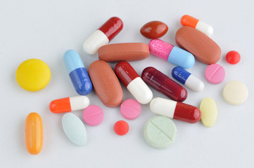 assortment of colorful pills and capsules isolated in white