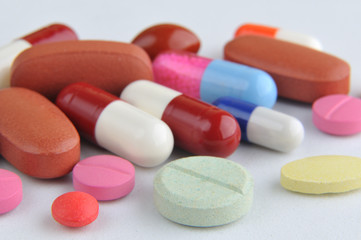 assortment of colorful pills and capsules isolated in white