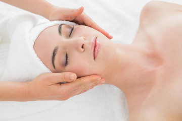 Fototapeta na wymiar Hands massaging woman's face at beauty spa