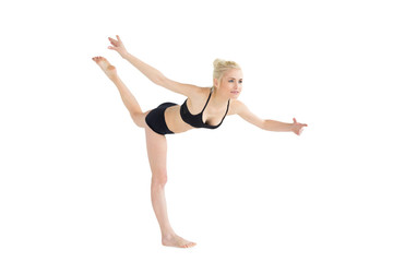 Fototapeta premium Sporty young woman balancing on one leg