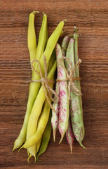 Yellow and green siliculose haricot on an old wooden background