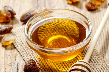 Bowl of honey on wooden table. Symbol of healthy living