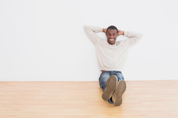 Afro young man sitting on floor in an empty room