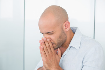 Sad casual man with hands to his face at home