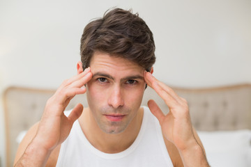 Close up of man suffering from headache in bed