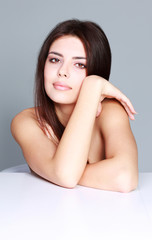 Beauty portrait of a young female model on gray background