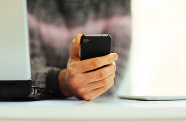 Closeup image of a male hand holding smartphone