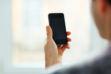Closeup image of a man looking at blank smartphone display