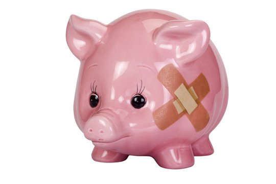 Close-up of a piggy bank with an adhesive bandage