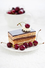 Portion of Opera cake decorated with fresh cherry
