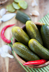 Pickled cucumbers in wooden bowl