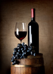 Red wine with barrel and grapes