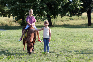 Obraz premium boy and little girl with pony horse pet