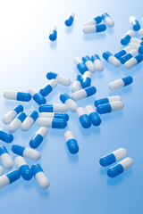 青色の背景に複数のカプセル剤
