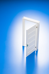 青色の背景に開いたミニチュアの扉