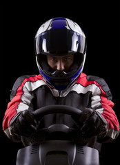 racerwearing red racing suit and blue helmet on a steering wheel