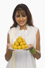 Obraz premium Woman holding Laddu in a plate on Holi