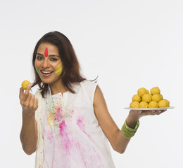 Obraz premium Woman showing Laddu on Holi