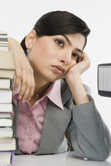 Stack of books in front of a businesswoman at desk