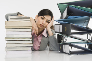 Stack of books in front of a businesswoman at desk